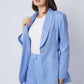 Woman wearing light blue blazer and matching pants with white top, fashion outfit