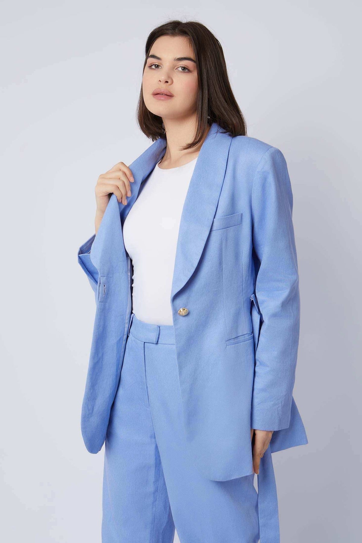 Woman wearing light blue blazer and matching pants with white top, fashion outfit