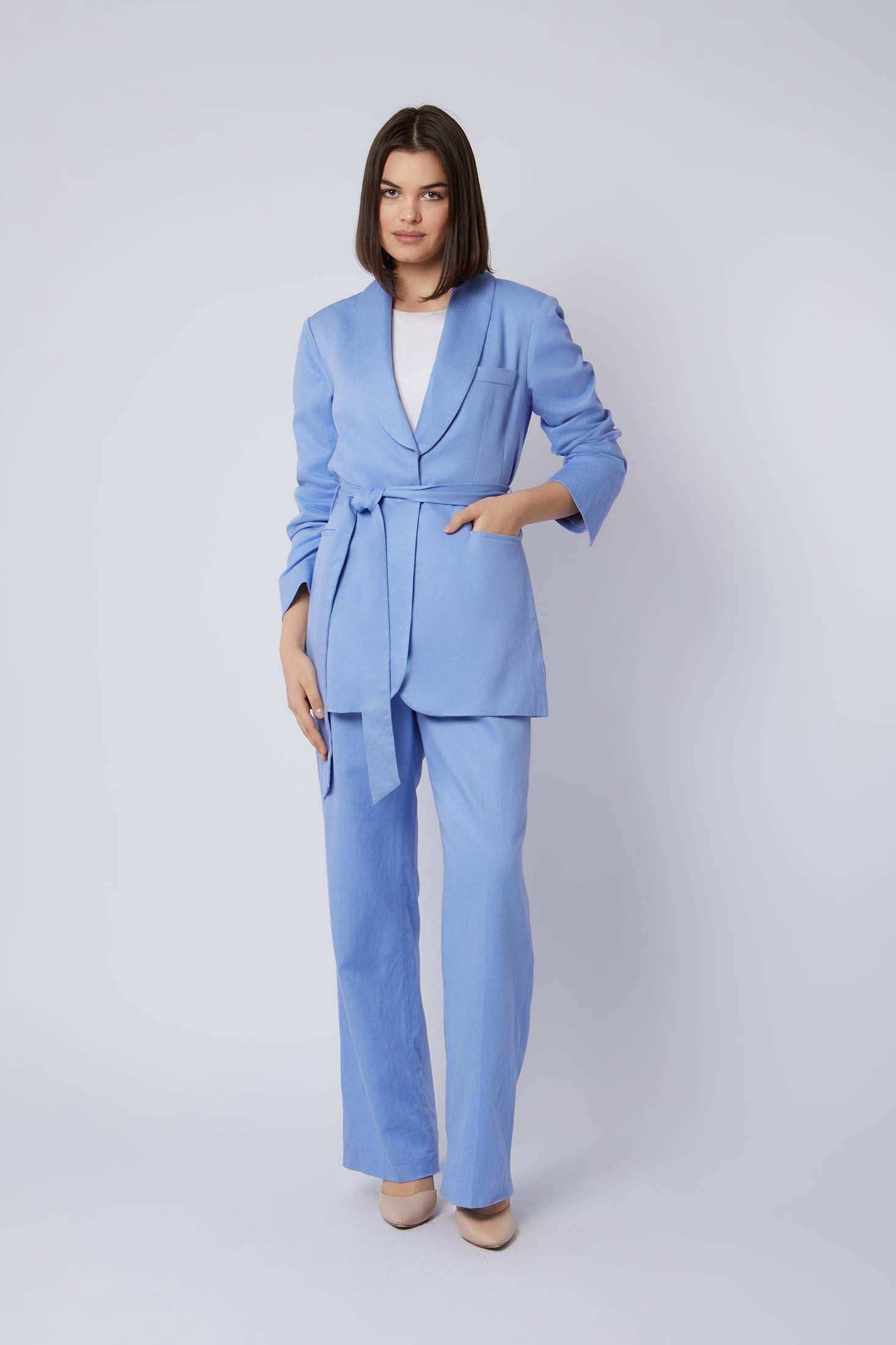 Woman wearing a light blue belted pantsuit with white top and beige heels