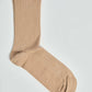 Beige ribbed crew sock on white background, casual men's or women's wear accessory